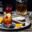 Old Fashioned cocktail garnished with a cherry served on a tray with slices of orange