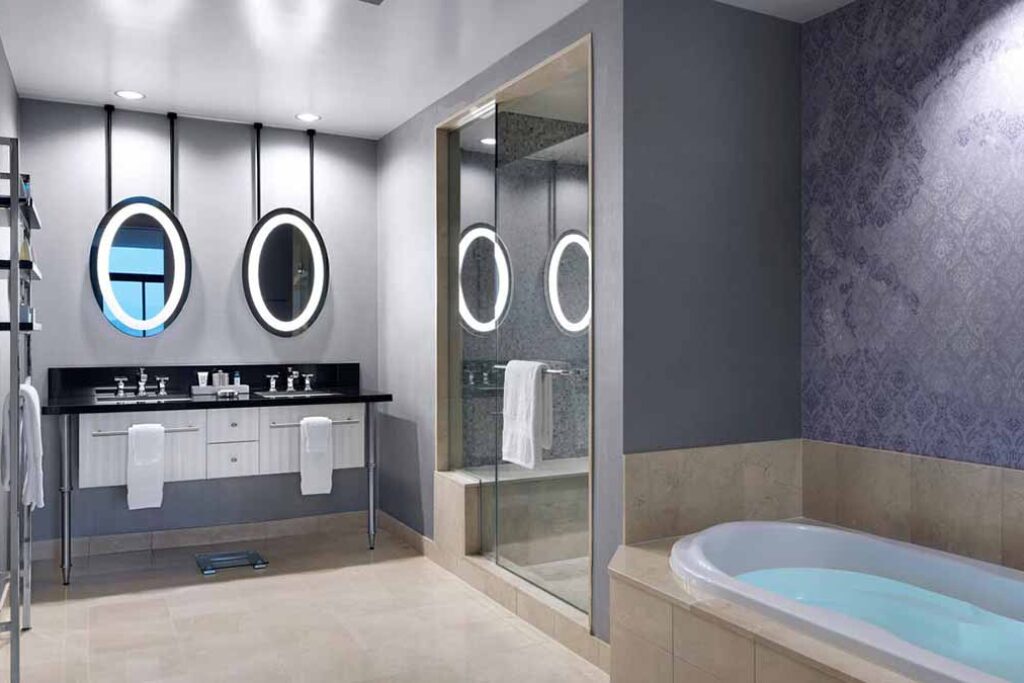 Suite bathroom with two sinks and bathtub