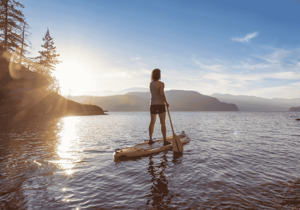 Adventurous Woman Paddle Boarding at Harrison Hot Springs, British Columbia, Canada