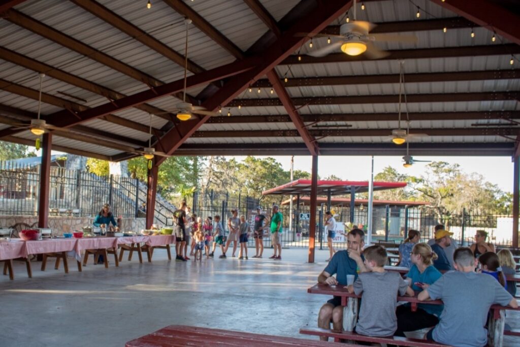 Covered outdoor dining area at Mayan Dude Ranch in Bandera, Texas, where guests enjoy family-style meals with fresh air and Hill Country views
