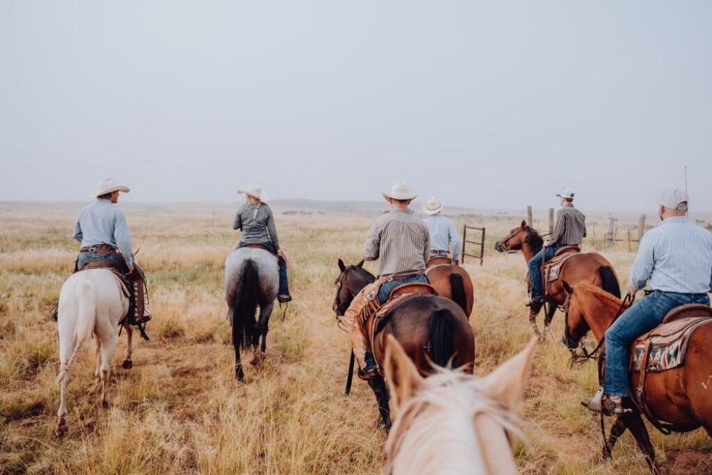 Group of people riding horses on a Texas ranch.