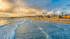 Waves in the Pacific Ocean and view of the beach at sunset, in Newport Beach, California