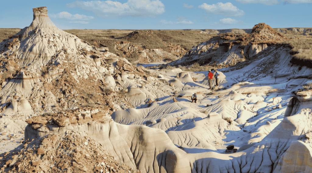 Tourists explore Dinosaur Provincial Park in Alberta, Canada, a UNESCO World Heritage Site noted for its striking badland topography and abundance of dinosaur fossils.