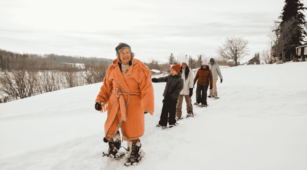 Kids being led on snowshoe by Indigenous women at Métis Crossing