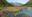 River running through wide open glacial valley full of blooming wildflowers in spring.