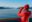 Alaska Glacier Bay cruise ship passenger looking at mountains with binoculars exploring Glacier Bay National Park.